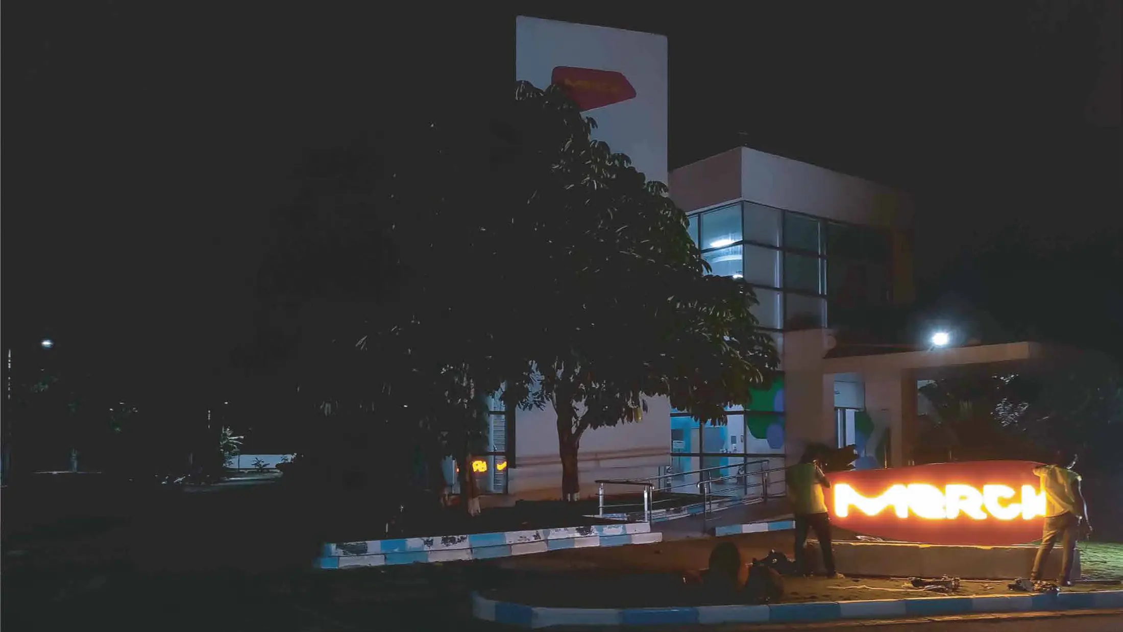 Installation of the illuminated Merck monument sign at night